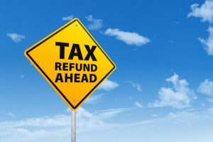 Tax refund concept with a road sign under blue sky