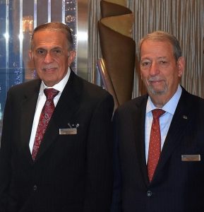 Nicholas Lorusso and Barry Minkin standing next to each other in black suits, with red ties.