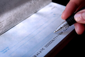 a person writing on a checkbook