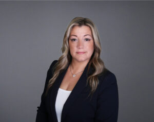 Portrait of a woman with blonde hair wearing a black blazer.