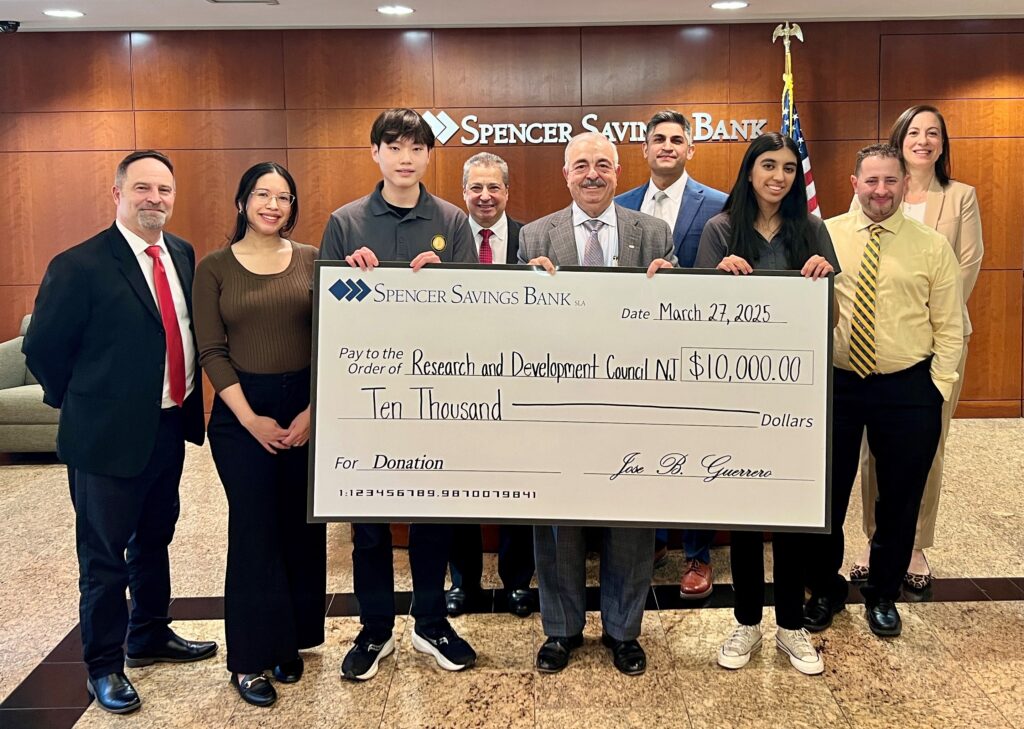 Students and bank representatives holding a check and smiling