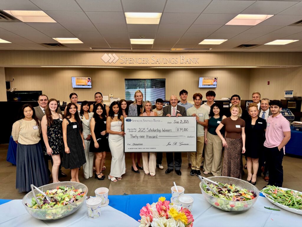 Scholarship students posing with check along with Spencer executive team