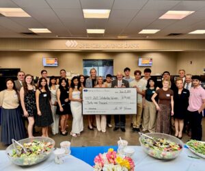 Scholarship students posing with check along with Spencer executive team