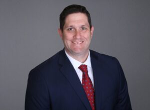 Portrait of man smiling, wearing a suit