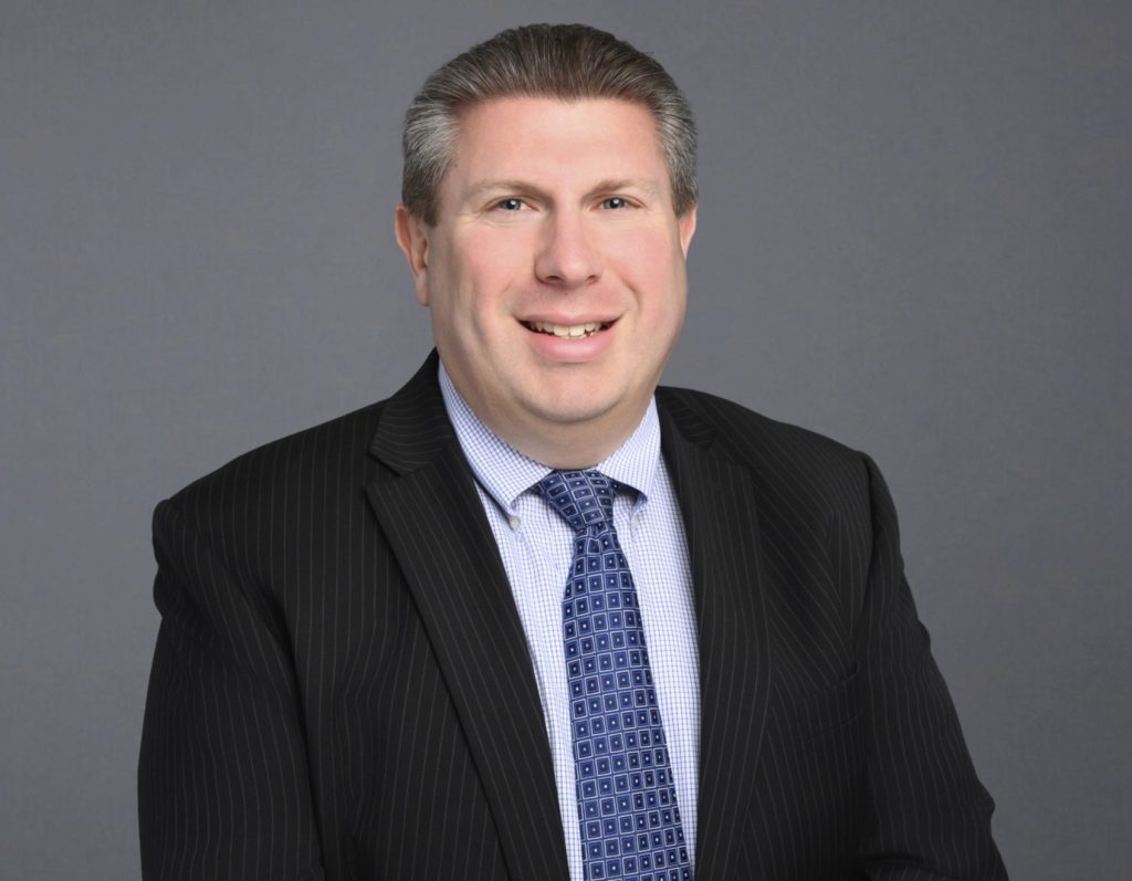 Portrait of Anthony Mattaliano smiling in suit and tie